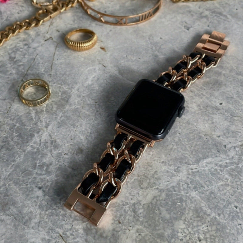 Bracelet Apple Watch en acier inoxydable rose doré avec lien cuir tressé noir et boucle brillante.