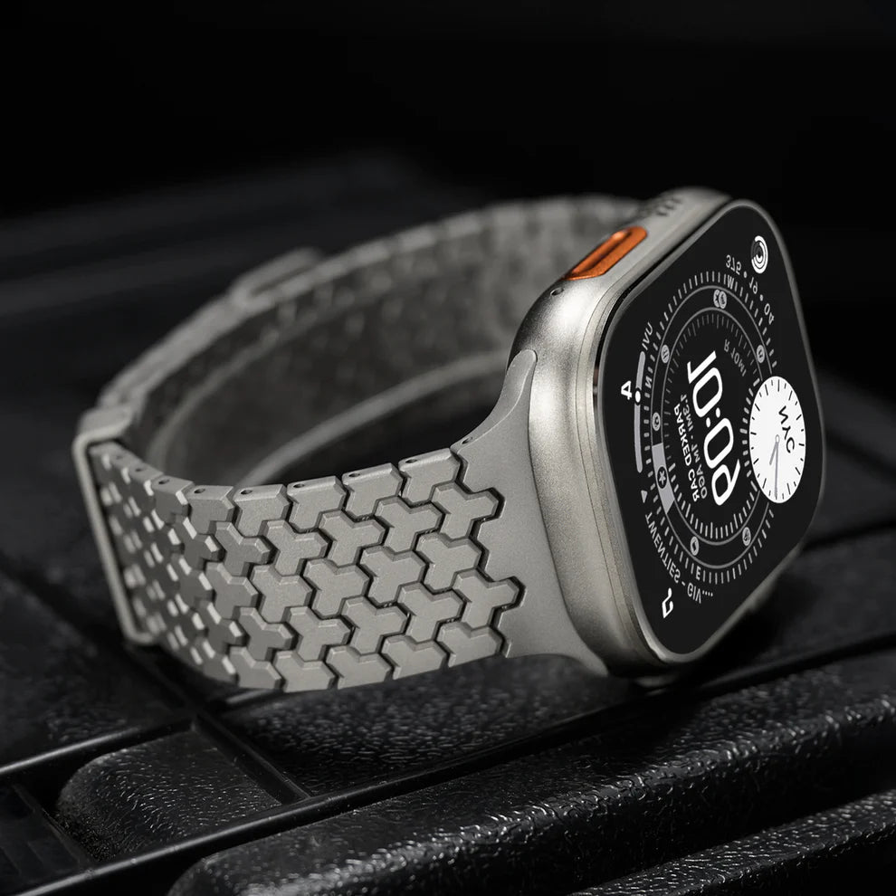 Bracelet Apple Watch en acier inoxydable gris à maillons hexagonaux, fermeture magnétique noire.