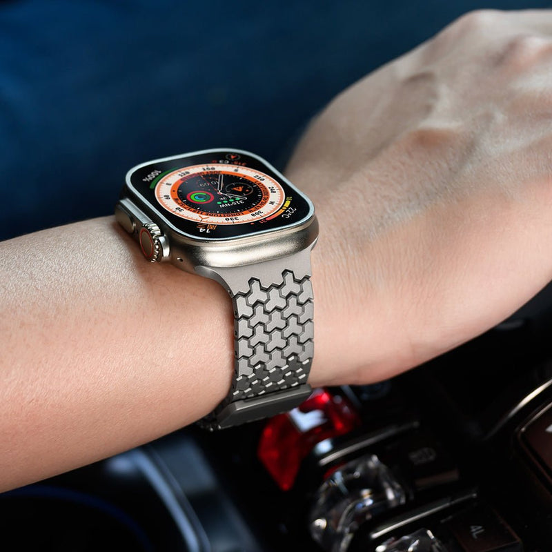 Bracelet Apple Watch en acier inoxydable gris foncé avec maillons hexagonaux et fermeture magnétique.