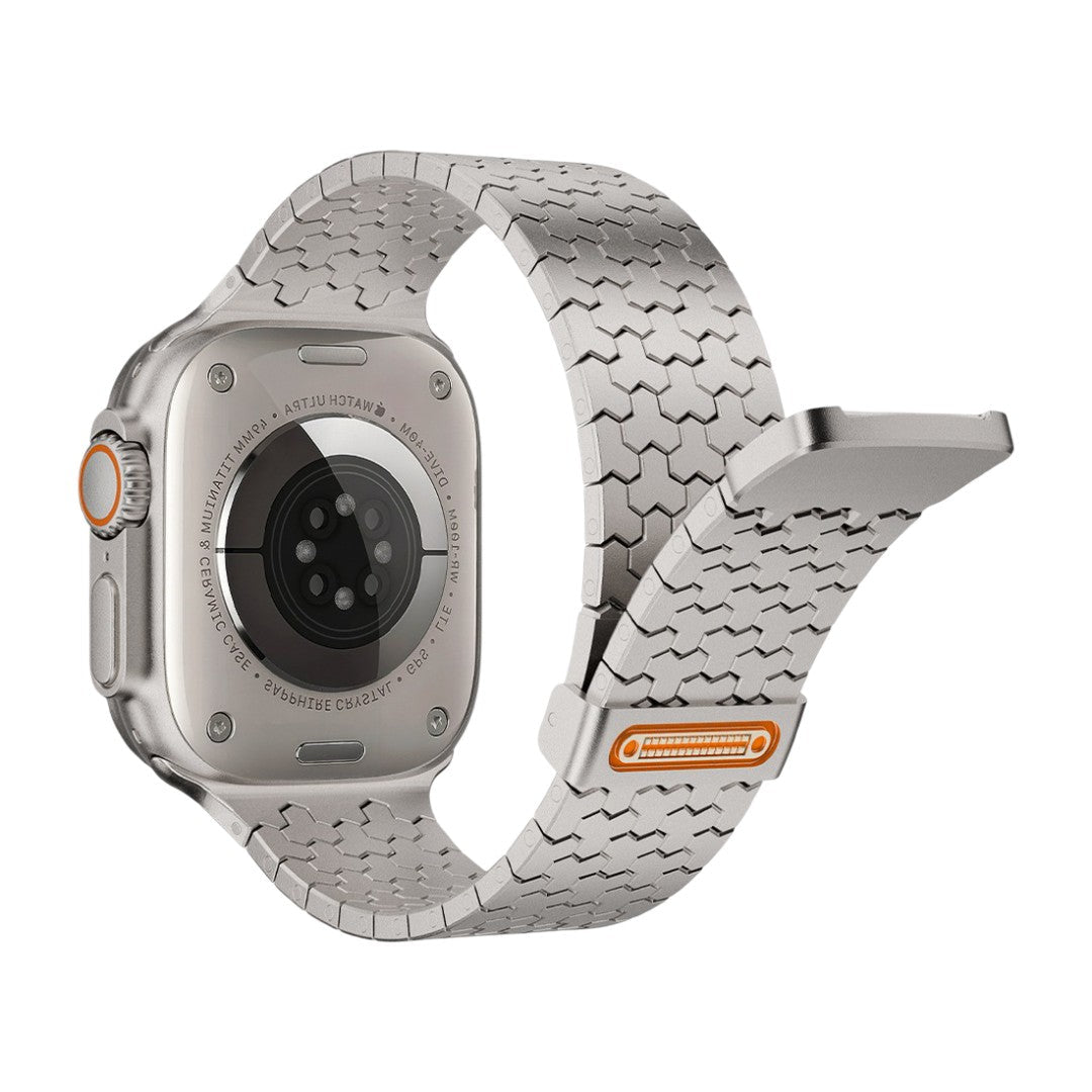Bracelet Apple Watch en acier inoxydable gris, maillons hexagonaux magnétiques, fermeture magnétique avec détail orange.