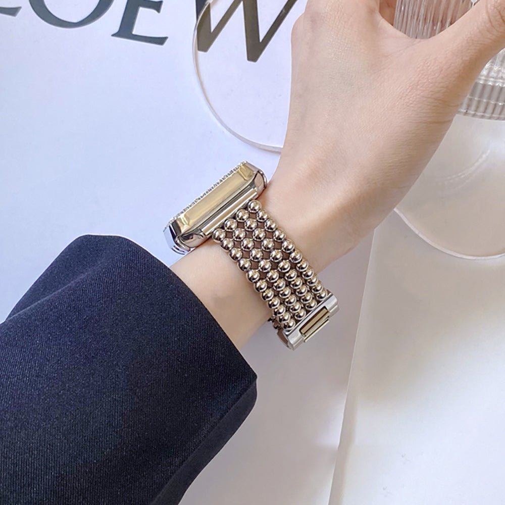 Bracelet Apple Watch en acier inoxydable finition perles métalliques couleur argent avec fermoir cliquet élégant, porté au.