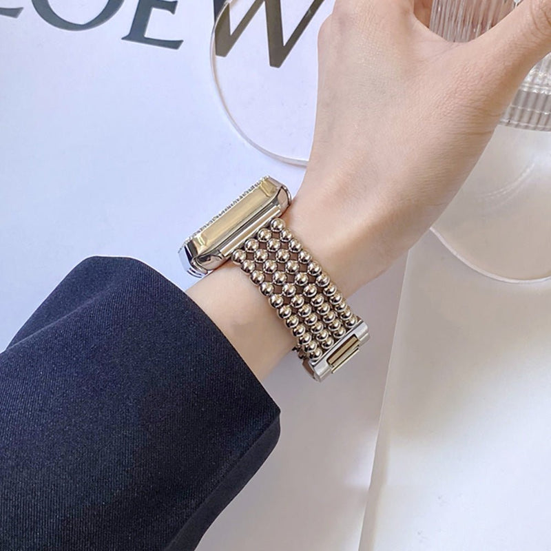 Bracelet Apple Watch en acier inoxydable finition perles métalliques couleur argent avec fermoir cliquet élégant, porté au.