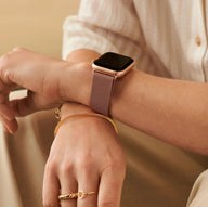Bracelet Apple Watch en acier inoxydable rose doré avec fermoir magnétique, style épuré et moderne, porté au poignet.