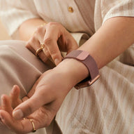 Bracelet Apple Watch en acier inoxydable rose doré avec boucle magnétique sur poignet féminin.