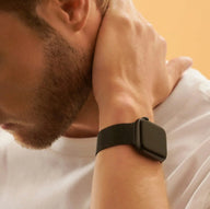 Bracelet Apple Watch en acier inoxydable noir avec fermoir magnétique, style mixte, porté au poignet.
