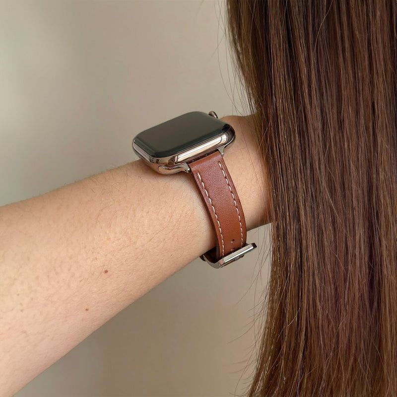 Bracelet Apple Watch en cuir marron avec couture contrastée blanche, style raffiné, boucle argentée.