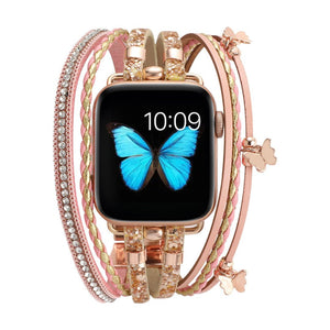 Bracelet Apple Watch en cuir rose multi-rangs avec strass brillants et papillons métalliques dorés, fermoir boucle élégante.