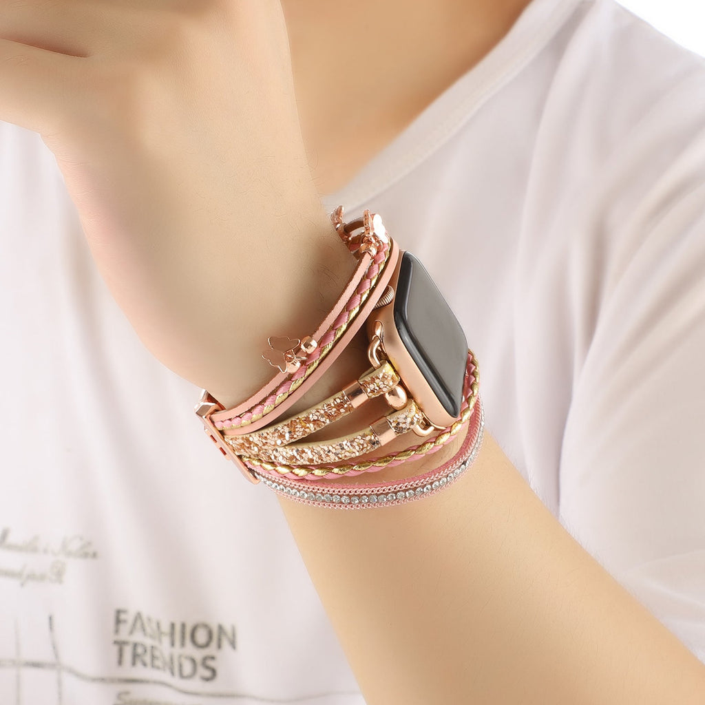 Bracelet multi-rangs pour Apple Watch en cuir rose clair avec papillons décoratifs et strass brillants, fermoir boucle.