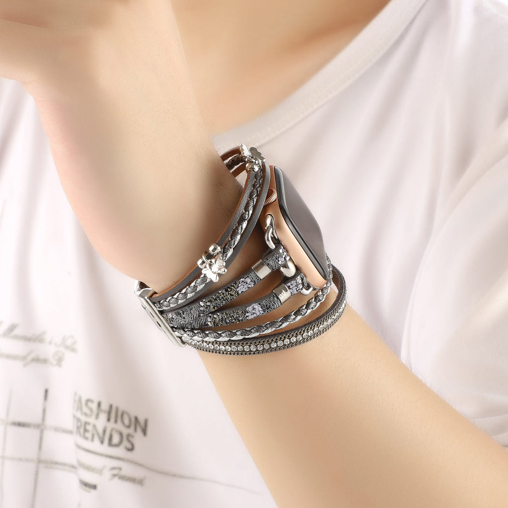 Bracelet Apple Watch multi-rangs en cuir gris avec strass brillants et petit papillon argenté, fermoir boucle élégant.