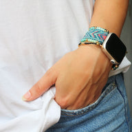 Bracelet Apple Watch en nylon tressé multicolore avec perles de cristal porté au poignet féminin.