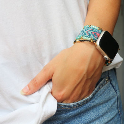 Bracelet Apple Watch en nylon tressé multicolore avec perles de cristal porté au poignet féminin.