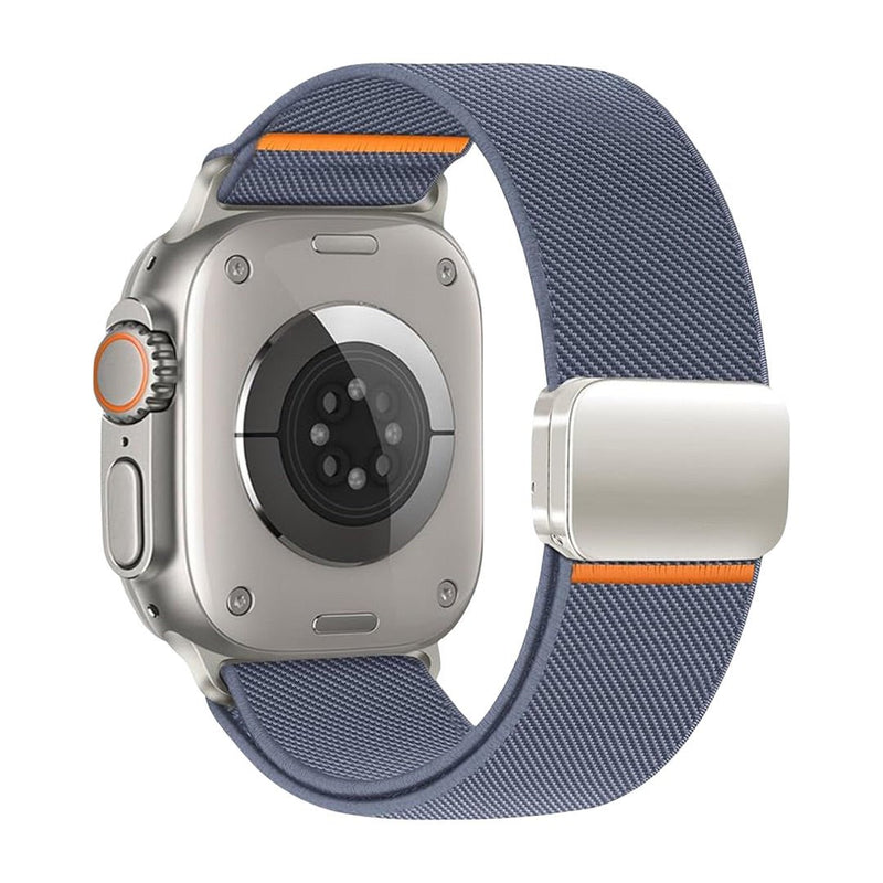 Bracelet Apple Watch en nylon bleu gris avec fermeture magnétique argentée et accent orange près de la boucle.