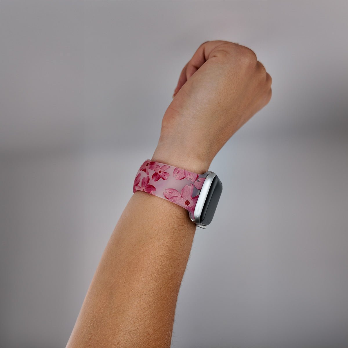 Bracelet Apple Watch en silicone rose à motifs floraux rouges, design féminin et élégant.