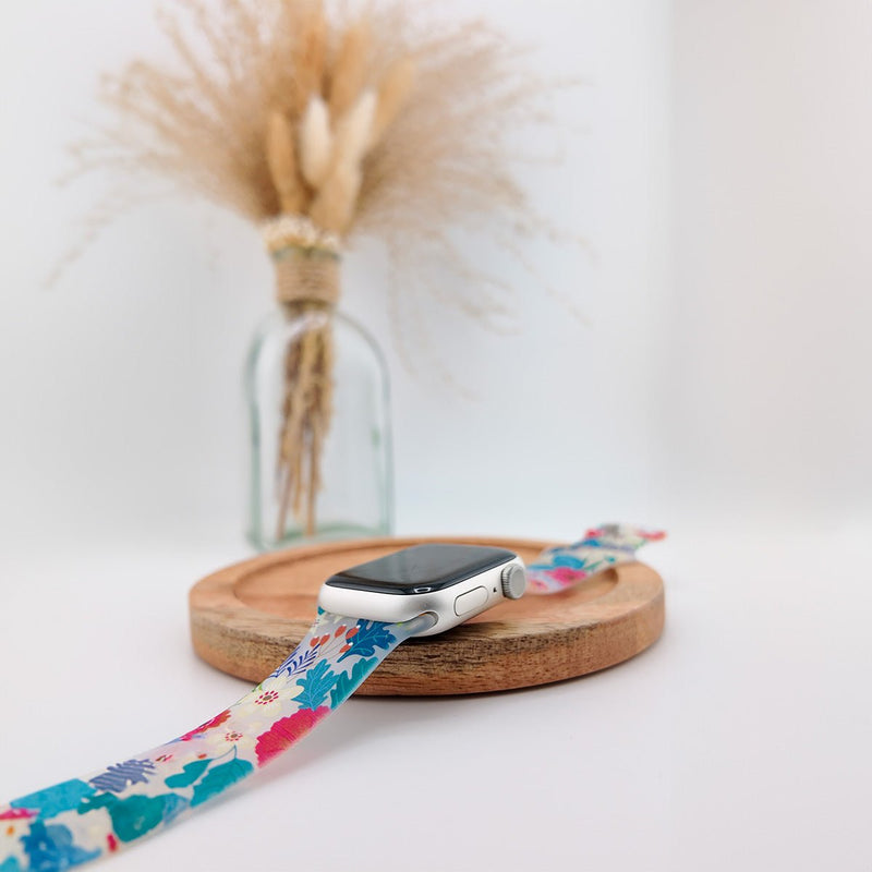 Bracelet Apple Watch en silicone avec motifs colorés abstraits rose, bleu et beige, modèle Saroa, pour femme.