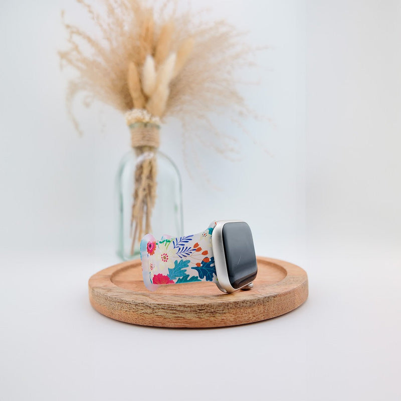 Bracelet Apple Watch en silicone blanc à motifs floraux colorés, style féminin et léger.