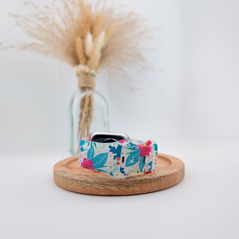 Bracelet Apple Watch en silicone blanc avec motifs floraux colorés rose et bleu, modèle femme Saroa.