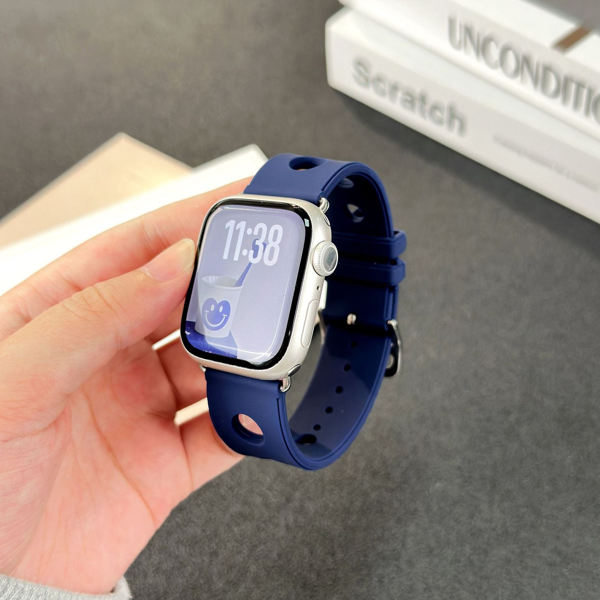 Bracelet Apple Watch en silicone bleu marine perforé avec fermoir en acier inoxydable, design respirant et moderne.