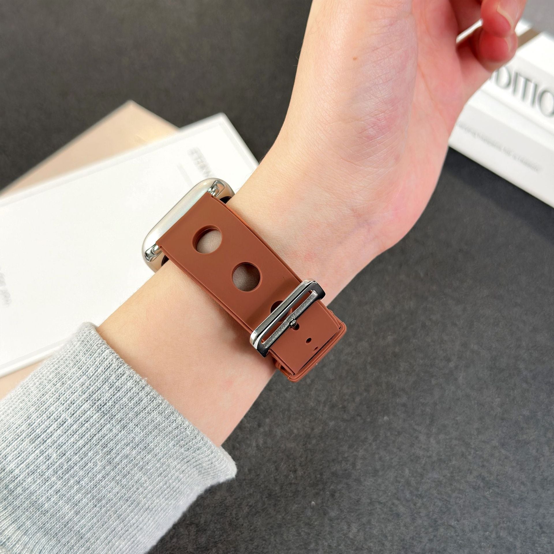 Bracelet Apple Watch en silicone marron perforé avec fermoir en acier inoxydable, style respirant et dynamique.