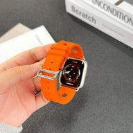 Bracelet Apple Watch orange en silicone perforé avec fermoir en acier inoxydable brillant.