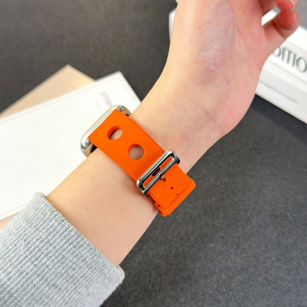Bracelet orange en silicone perforé pour Apple Watch avec fermoir en acier inoxydable brillant.