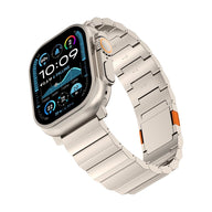 Bracelet pour Apple Watch en titane argenté, maillons larges, fermoir magnétique avec détails orange, design moderne et.