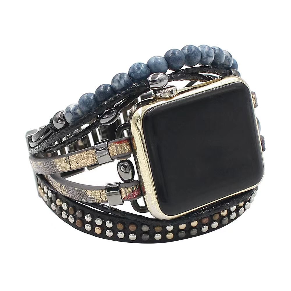 Bracelet pour Apple Watch style manchette large en cuir tressé noir avec pierres naturelles bleu-gris et clous métalliques.