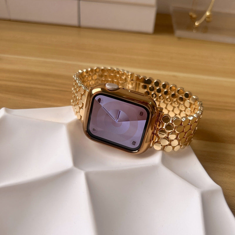Bracelet Apple Watch femme doré en métal avec mailles alvéolées style ruche et fermoir invisible.