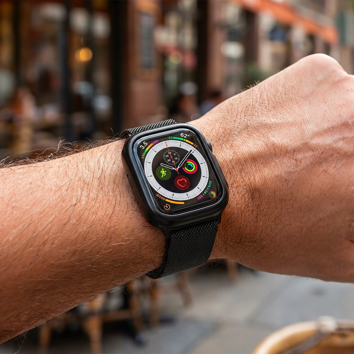 Bracelet Apple Watch maille milanaise noire en acier inoxydable avec fermoir magnétique et coque de protection intégrée.