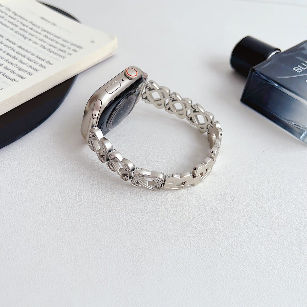 Pulseira para Apple Watch em metal prateado com malhas entrelaçadas, motivo de nó infinito cravejado de zircónias, fecho de encaixe ajustável, modelo Zergone