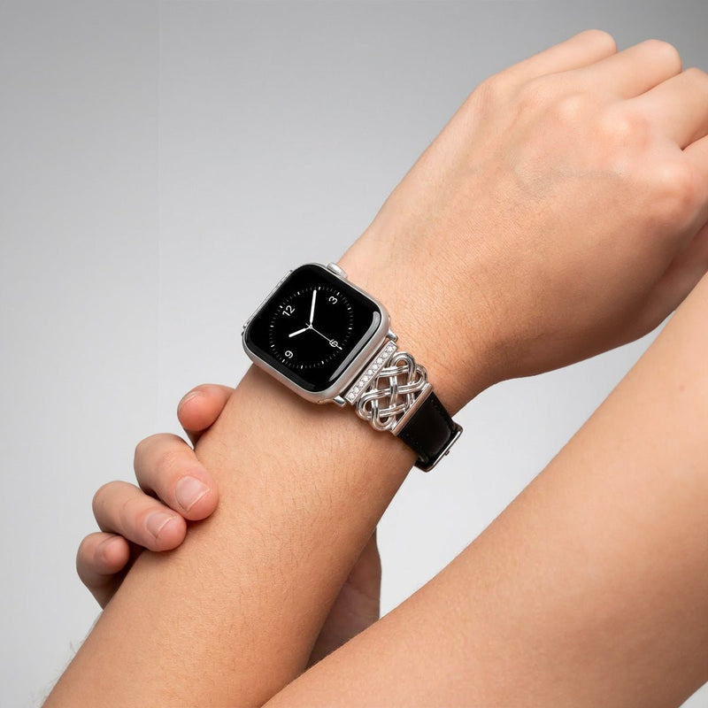 Bracelet Apple Watch en cuir noir avec motif tressé métal argenté et zircon en noeud celtique élégant.