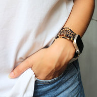 Bracelet Apple Watch femme marron motif léopard en silicone ajustable porté au poignet.