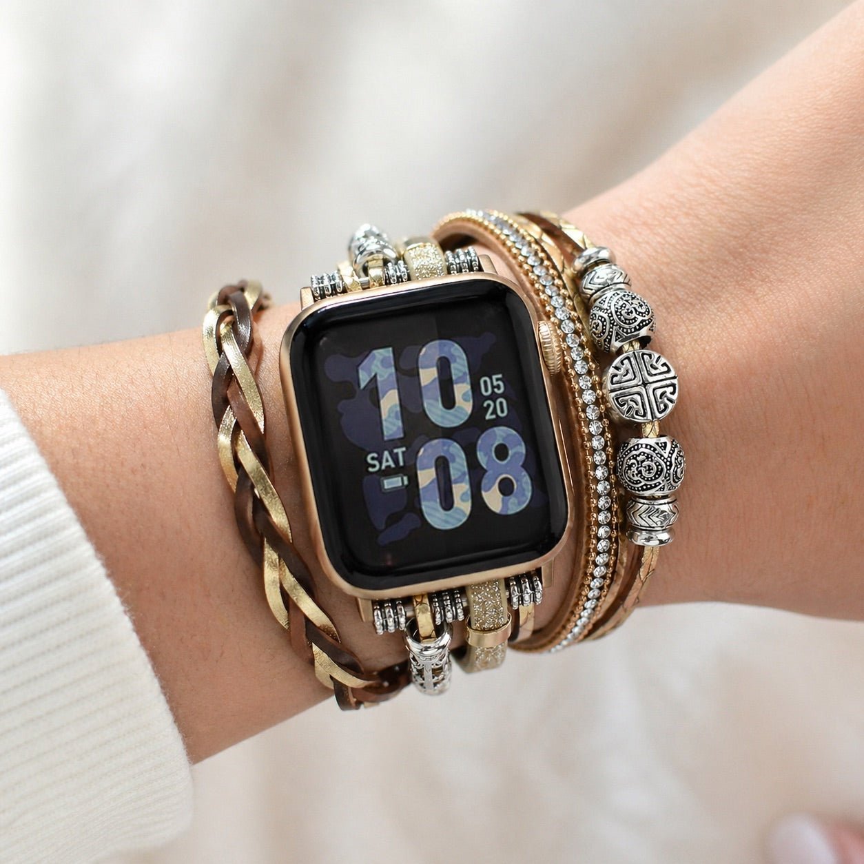 Apple Watch armbånd i flere rækker, guldfarvet, justerbart håndledssmykke med flettede remme og metalperler, elegant tilbehør til smartwatch, blank og tekstureret finish, model Rédine