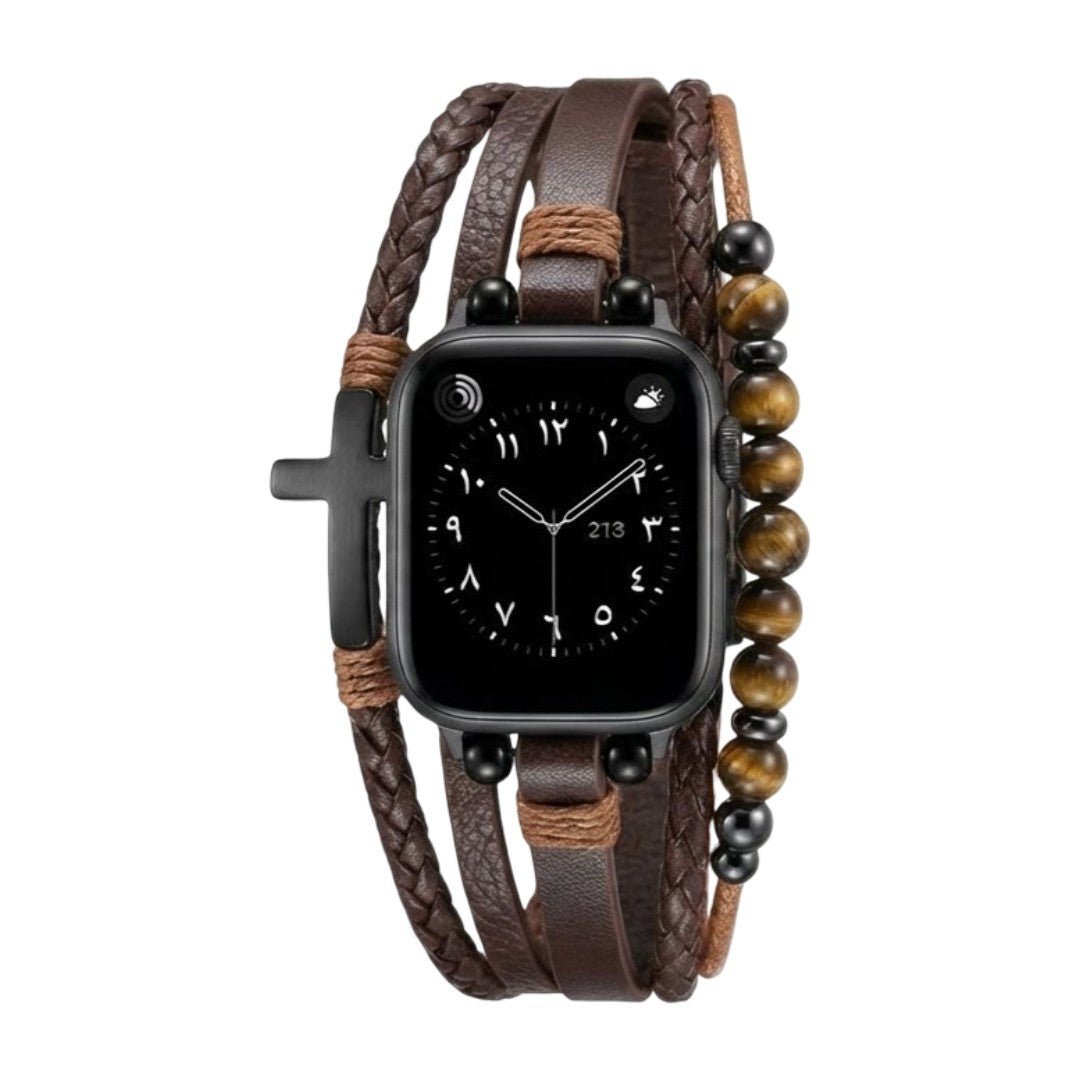 Bracelet multi-rangs en simili cuir vegan marron avec perles œil de tigre et croix noire attachées à une Apple Watch noire.