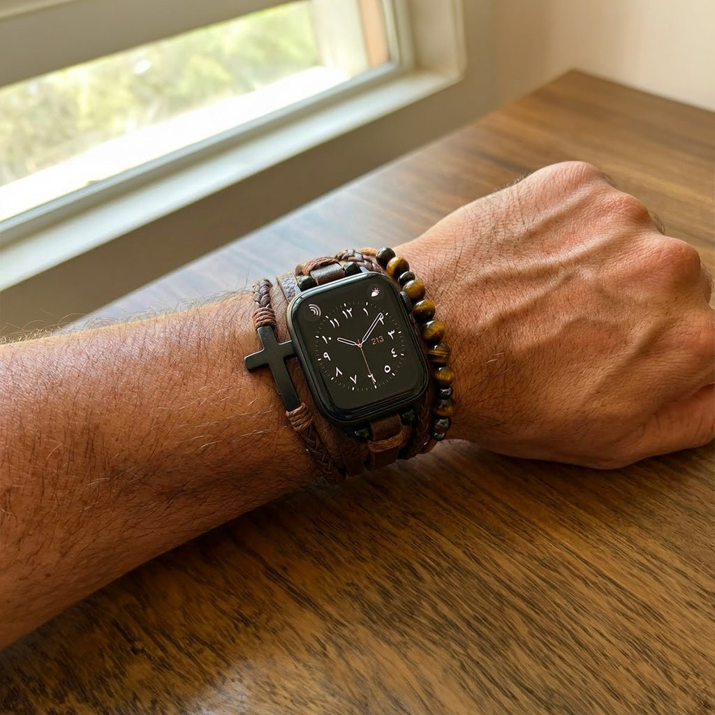Bracelet multi-rangs simili cuir vegan marron avec perles œil de tigre et croix noire porté avec Apple Watch noire sur.