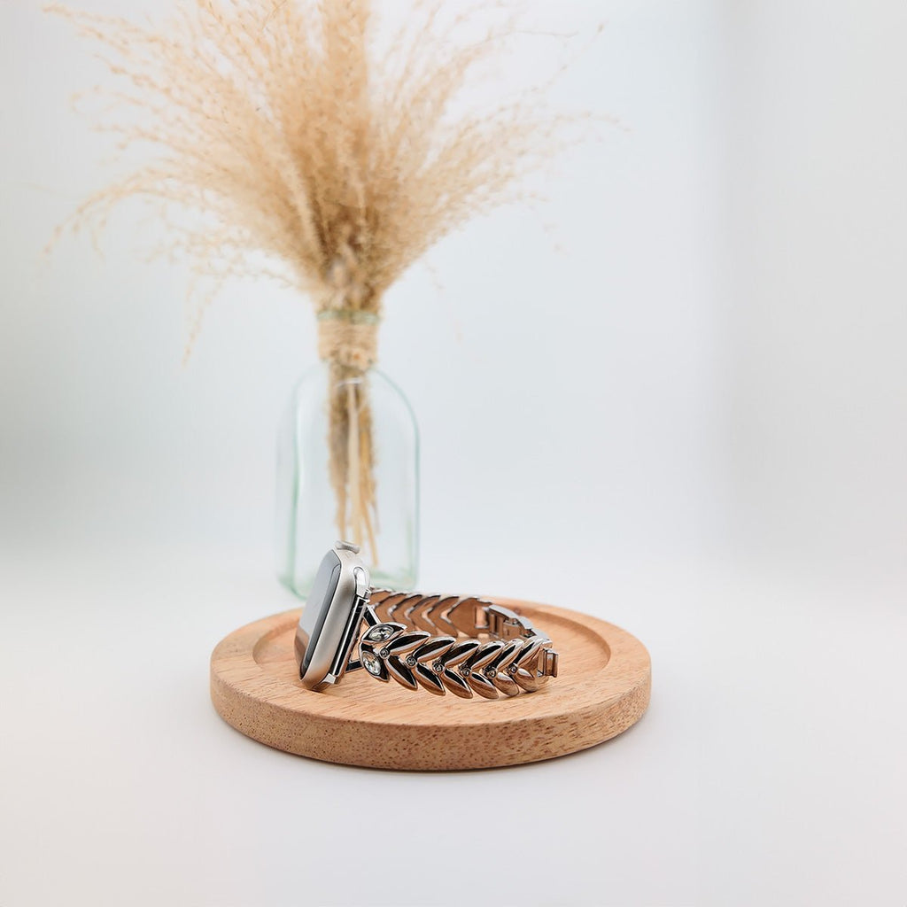 Bracelet Apple Watch féminin en métal argenté, design feuilles imbriquées, style chic.