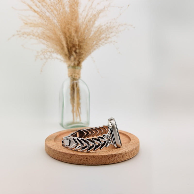 Bracelet argenté pour Apple Watch avec maillons en forme de feuilles imbriquées, style chic et élégant.
