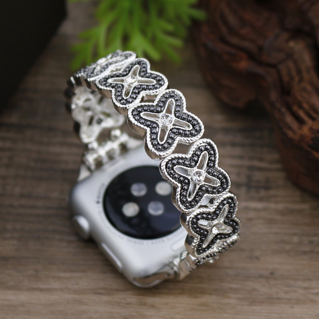 Apple Watch Armband mit durchbrochenem Blumenmuster, Strasssteinen und zweifarbiger Ausführung, Modell Harpie