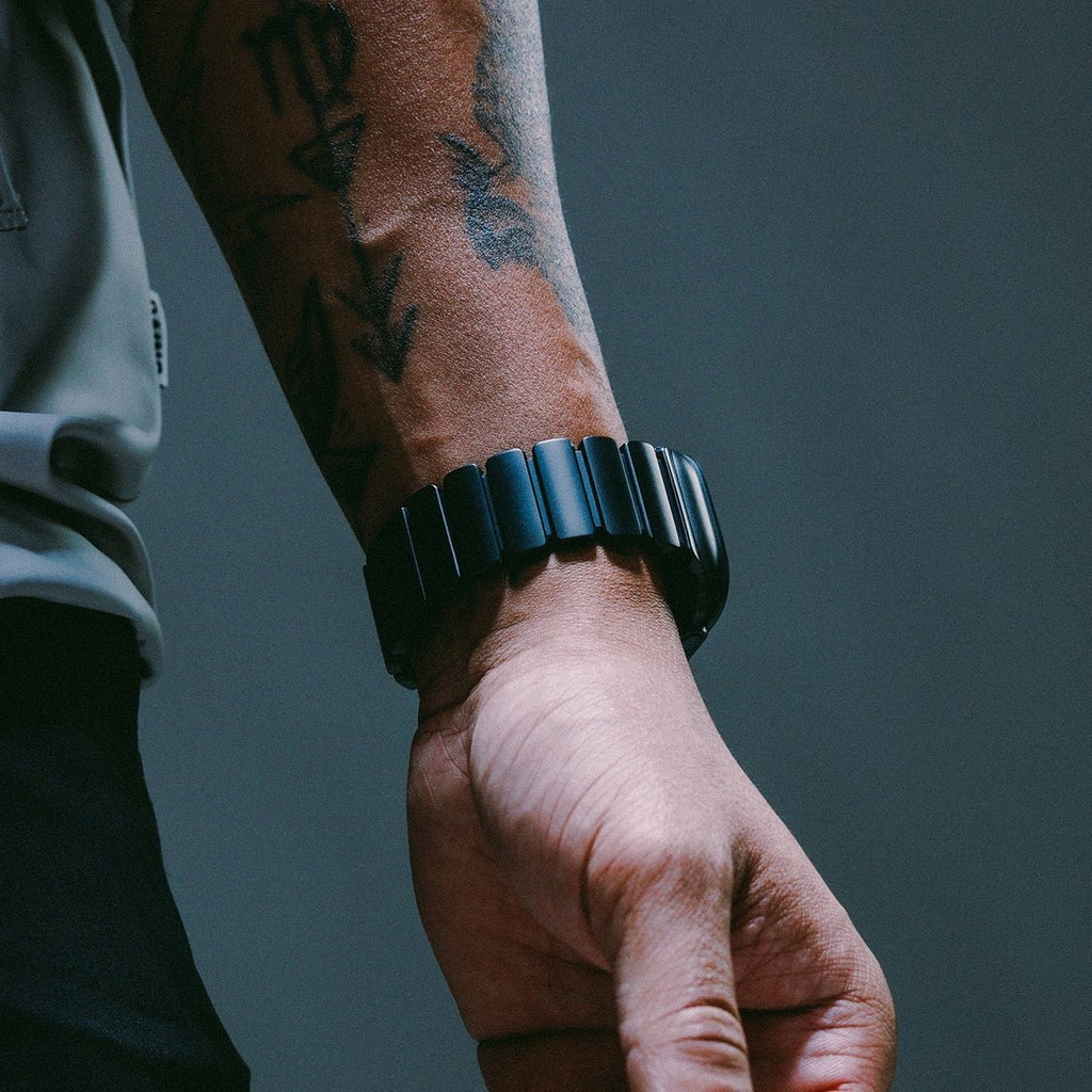 Bracelet Apple Watch en titane noir mat et caoutchouc FKM noir souple, boucle déployante, design robuste et élégant.