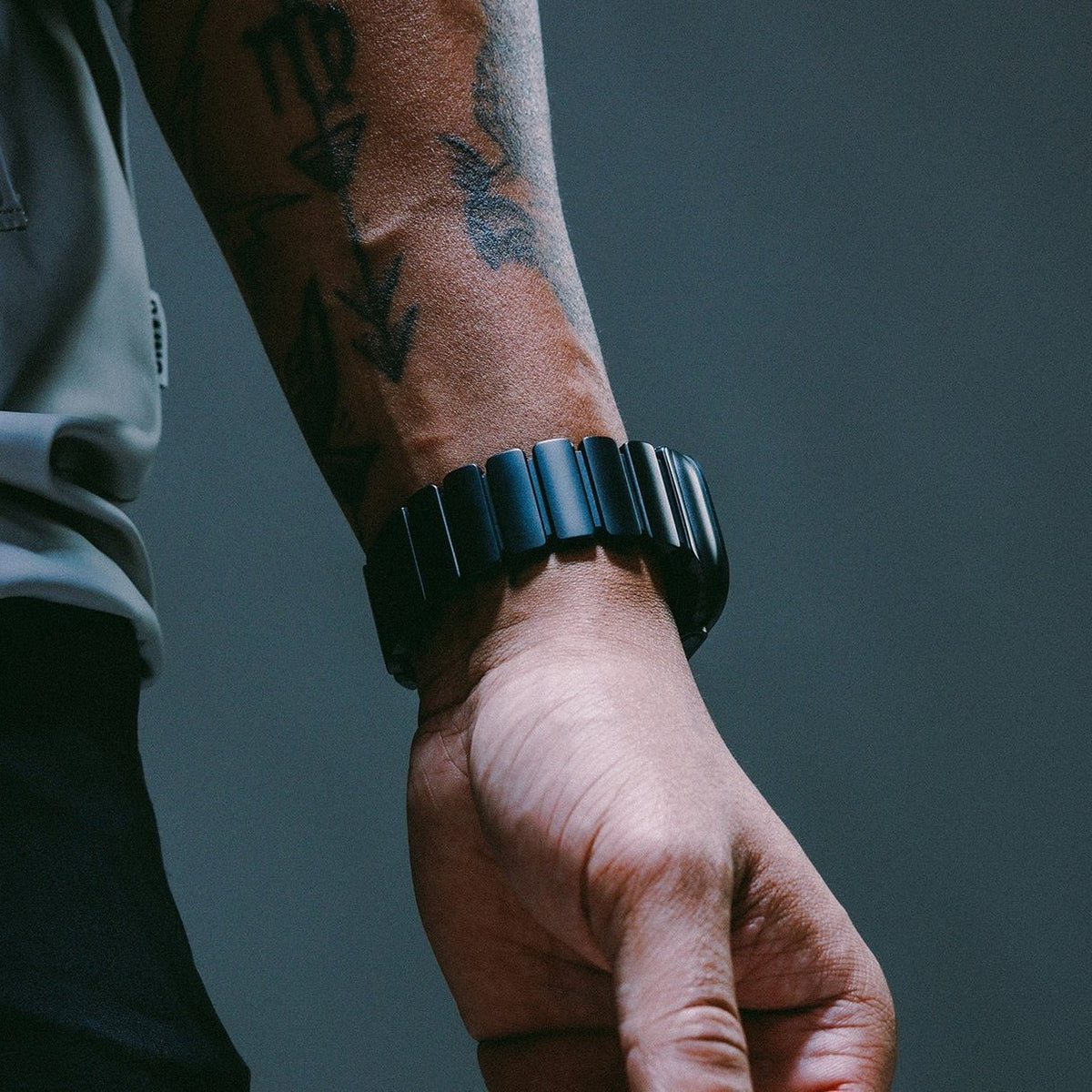 Bracelet Apple Watch en titane noir mat et caoutchouc FKM noir souple, boucle déployante, design robuste et élégant.