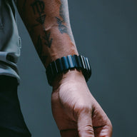 Bracelet Apple Watch en titane noir mat et caoutchouc FKM noir souple, boucle déployante, design robuste et élégant.