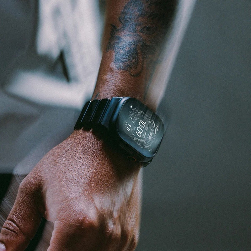 Bracelet Apple Watch en titane noir mat avec maillons robustes et design souple, porté au poignet.