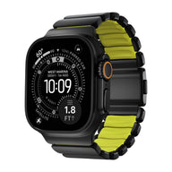 Bracelet Apple Watch souple titane noir avec intérieur vert fluo, maillons larges et fermeture robuste.