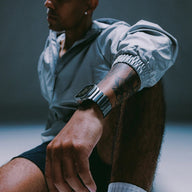 Bracelet Apple Watch en titane gris mat avec maillons larges, style robuste et moderne, porté sur poignet masculin.