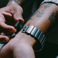 Bracelet Apple Watch en titane Grade 4 gris métallisé avec maillons larges, fermoir ajustable robuste en FKM noir, style.