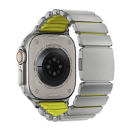 Bracelet Apple Watch Ultra en titane gris clair avec intérieur et accents jaunes, design souple et segments larges.