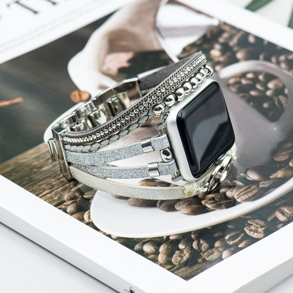 Bracelet Apple Watch multi-rangs argenté en simili cuir avec strass brillants et anneaux entrelacés, fermoir ajustable.