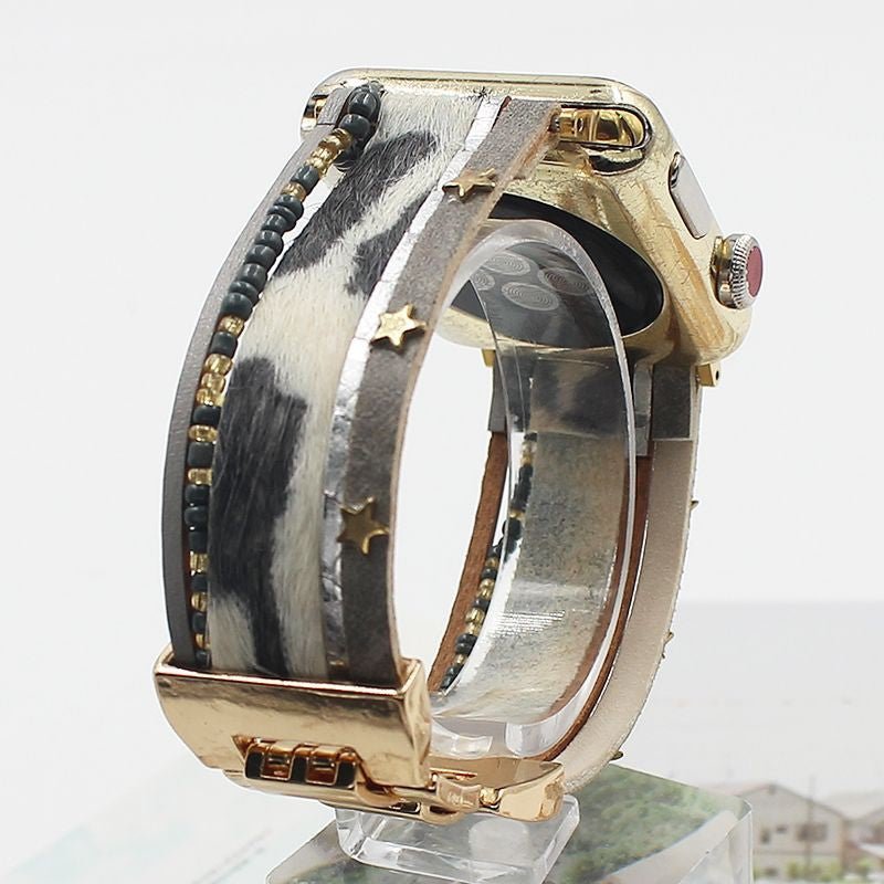 Bracelet Apple Watch simili cuir animalier imprimé vache gris blanc, perles naturelles noires, fermoir doré étoiles.