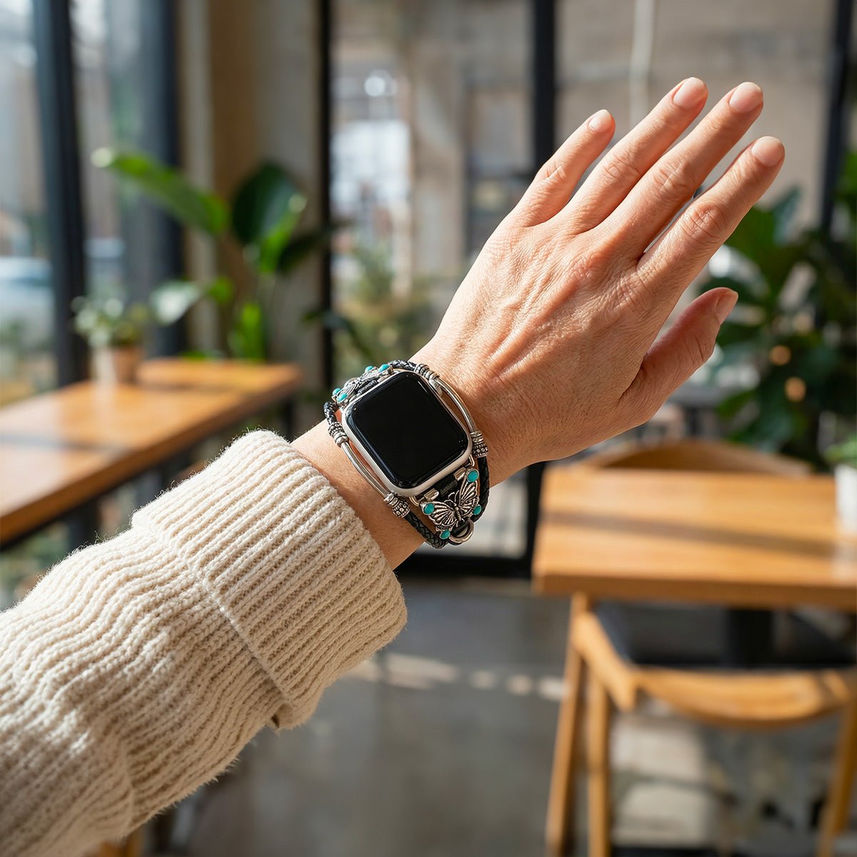 Bracelet Apple Watch noir tressé simili cuir vegan avec papillon argenté et perles turquoise élégantes.
