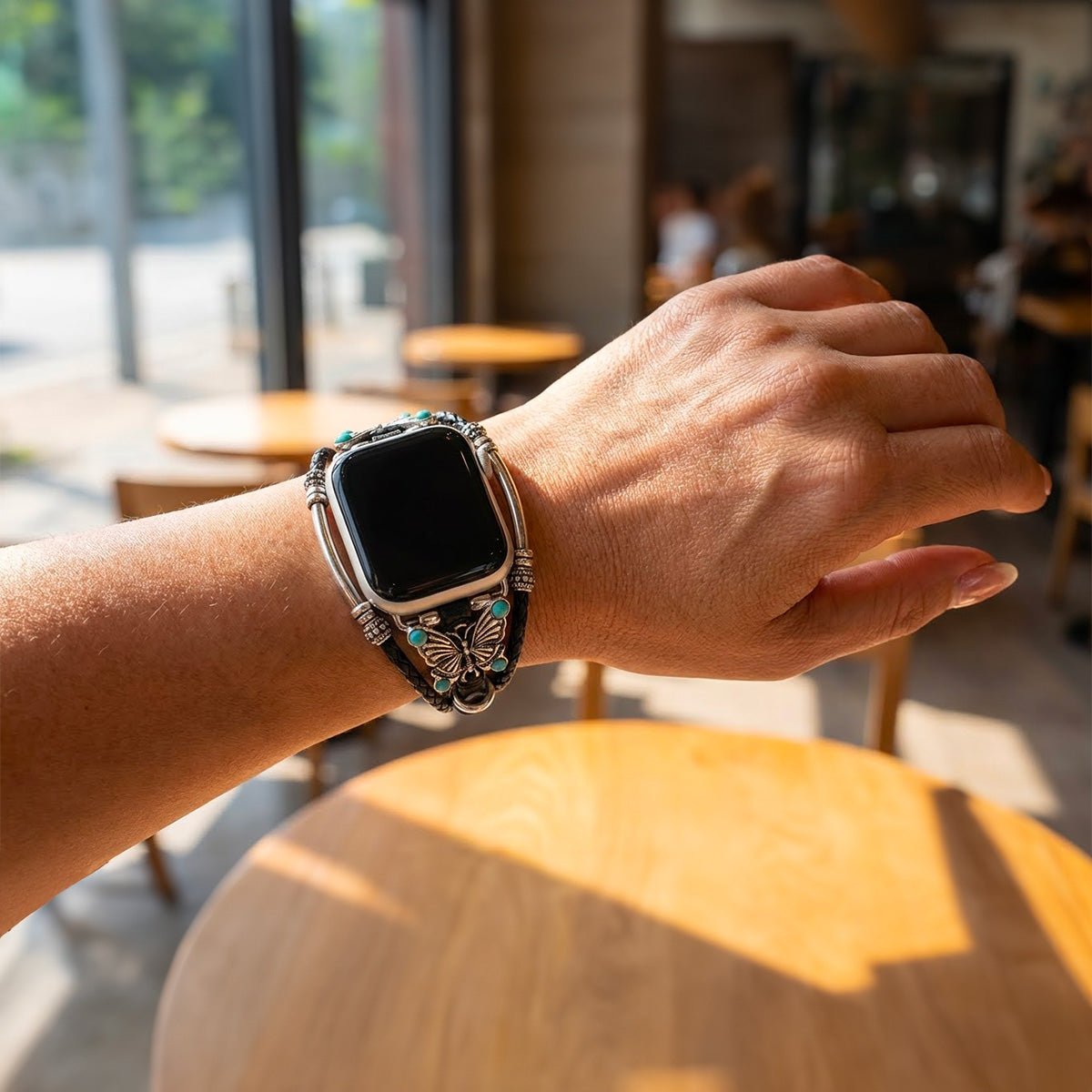 Bracelet Apple Watch en simili cuir vegan noir tressé avec papillon argenté et perles turquoise élégantes.