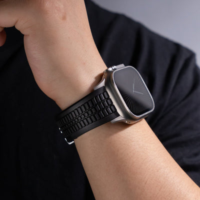 Bracelet Apple Watch sport noir en silicone texturé avec boucle ajustable double sur poignet.